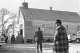 People entering a wooden church building in rural Prattville, Alabama, probably for a meeting of the Autauga County Voters Association.