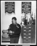 Member of LAPD Deputy Auxiliary Police basketball team with trophy, circa 1946, Los Angeles