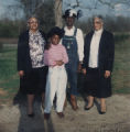 Ruth Datcher standing outside with a child and two of her siblings, Jimmie Garrett and Nell Lee.