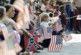 Spectators waving American flags at the Veterans Day parade in Birmingham, Alabama.