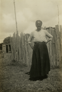 Gullah woman standing in front of a fence