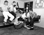 Unidentified jazz band socializing with a woman playing conga drums, August 2, 1952