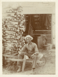 Man seated on wheelbarrow