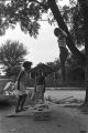 Diane Foster and Elizabeth Ellis playing on a make-shift seesaw in the dirt yard in front of a brick house in Newtown, a neighborhood in Montgomery, Alabama.