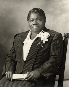 Mary McLeod Bethune sitting, half length, frontal, holding paper, wearing striped suit with corsage : acetate film photonegative plus two enlarged prints