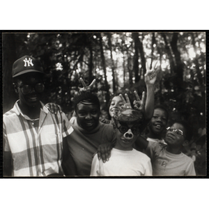 A Group of youth posing and smiling in a wooded area