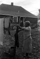 Mrs. Rosa Lee Turner hanging laundry on a clothesline in the dirt yard behind her house in Montgomery, Alabama.