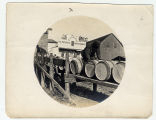 Workers roll barrels in shadow of general store