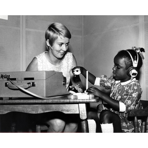 A Northeastern student at the Special Education Deaf Institute conducting a hearing test on a child