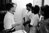 Man explaining scientific equipment to a group of young women from Lee County, Alabama, during a field trip to Auburn University.