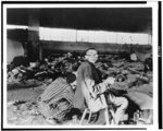 [Prisoners having meager meal among the dead in slave labor camp, Nordhausen, Germany after liberation by First U.S. Army]