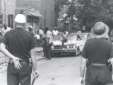 Police watch citizens gathered on street after riot, Rochester, NY, 1964