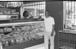 Mr. Arsonond poses at a meat counter, Los Angeles, 1986