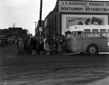 Large group of people on the corner in front of a bus on North McDonough Street in downtown Montgomery, Alabama.