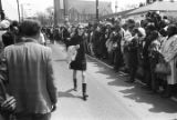 Mary Ellen Gale, Southern Courier reporter, walking down Auburn Avenue during Martin Luther King, Jr.'s funeral procession.