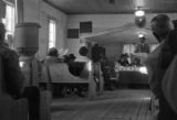 Norman Lumpkin speaking to an audience in a small wooden church building in Prattville, Alabama, probably during a meeting of the Autauga County Voters Association.