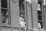 African Americans looking through windows that were blown out during the bombing of 16th Street Baptist Church in Birmingham, Alabama.