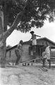 Elizabeth Ellis and Diane Foster playing on a make-shift seesaw in the dirt yard in front of a brick house in Newtown, a neighborhood in Montgomery, Alabama.