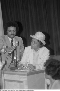 Photograph of woman standing at podium addressing crowd