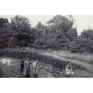 A group of boys splash in the lake at Breezy Meadows Camp