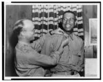 [Colonel Richard C. Cumming putting insignia on Chaplain Douglas L.T. Robinson, Tuskegee Army Air Field, Alabama]