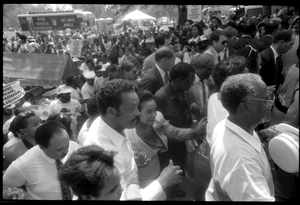 Speakers arriving at the 25th Anniversary of the March on Washington Jesse Jackson, Coretta Scott King (front center), Joseph Lowery (to right of King), Benjamin Hooks (to right of Lowery), and other speakers approach the stage through the crowd