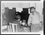 [African American man and woman at small stove]