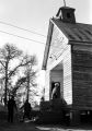 People entering a wooden church building in rural Prattville, Alabama, probably for a meeting of the Autauga County Voters Association.