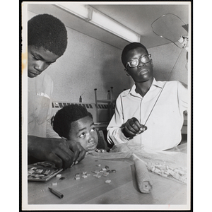 Three boys working on projects for their arts and crafts class at the Boys' Clubs of Boston