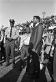 Muhammad Ali standing with Al Dixon, a disc jockey for radio station WXBI, on the football field during homecoming activities for Alabama State College on Thanksgiving Day in Montgomery, Alabama.