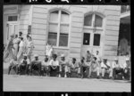 Negroes sitting on the curb waiting for the parade, National Rice Festival, Crowley, Louisiana