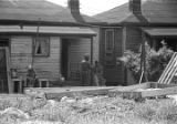 People outside a small clapboard house in Little Korea, a neighborhood in Birmingham, Alabama.