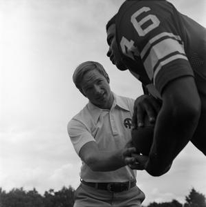 Football coach standing with a player, 2