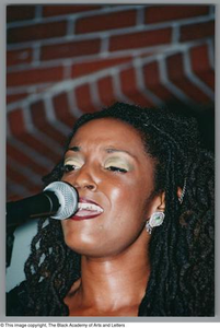 Photograph of Rhea singing into a microphone