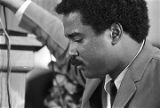 Norman Lumpkin, news director for WRMA radio, holding a microphone while Martin Luther King, Jr., speaks to a crowd at Maggie Street Baptist Church in Montgomery, Alabama.