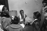 Children in the group "Buds of Promise" from Mt. Zion AME Zion Church in Montgomery, Alabama, singing to an elderly woman in her home.