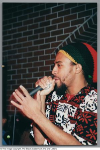 Photograph of a man rapping into a microphone