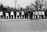 Civil rights demonstrators standing across Sylvan Street in Selma, Alabama, holding signs that spell "Selma Wall."