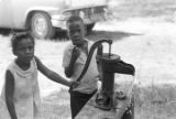 Children getting water from a hand pump during a cookout in the Madison Park community in Montgomery, Alabama.