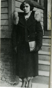 Young Henrietta Cephas Brown standing in front of a house