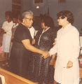 Women Shaking Hands in Church Pew