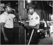 Two Atlanta police officers phone in to the station on a night watch, 1965