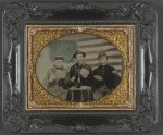 [Three unidentified soldiers playing cards, smoking, and drinking in front of American flag]