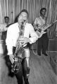 Bobby Moore playing the saxophone on stage at the Laicos Club in Montgomery, Alabama, during a performance with his group, the Rhythm Aces.