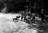 Man, woman, and children standing at the side of an unpaved road, observing a march in Prattville, Alabama, during a demonstration sponsored by the Autauga County Improvement Association.