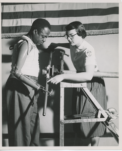 Occupational therapist instructing man on how to use his artificial arm for heavy duty work