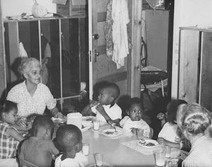 Evelyn House with children at lunch time, Hallie Q. Brown nursery school, St. Paul.