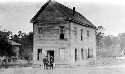 Unidentified school with undentified men and child in front