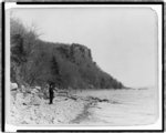 [Man standing on banks of the Hudson River near the Palisades]