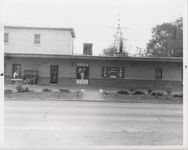 Mississippi State Sovereignty Commission photograph taken from across the street of the front entrance to Stanley's Cafe and Trailways bus depot with two men standing outside, Winona, Mississippi, 1961 November 1